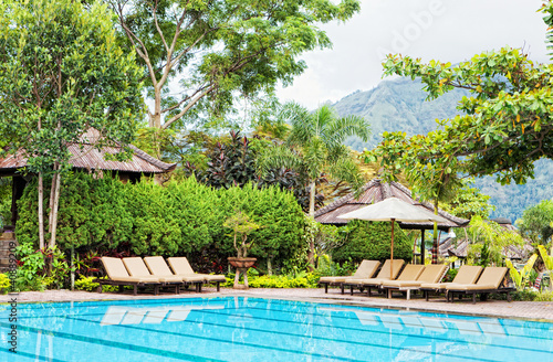 Chaise lounges at pool in hotel in tropics