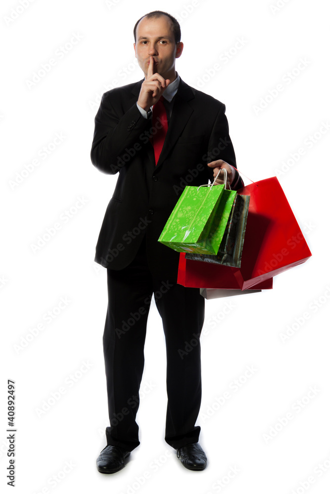 Businessman with shopping bags and making quiet sign with hand Businessman with shopping bags and making quiet sign with hand