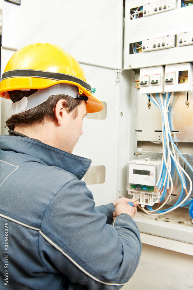 Electrician installing energy saving meter Electrician installing energy saving meter