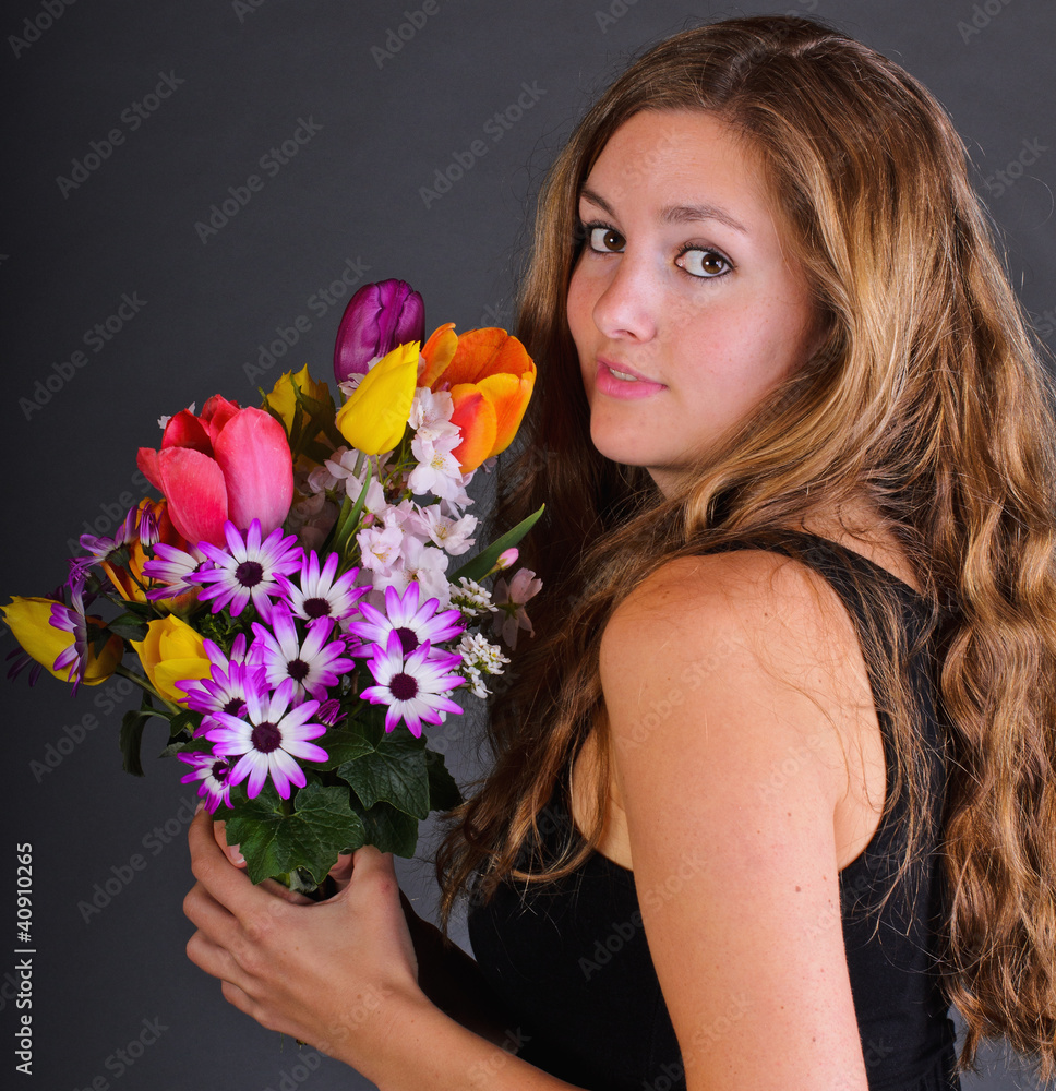 Young, beautiful woman with a colorful bouquet of spring flowers