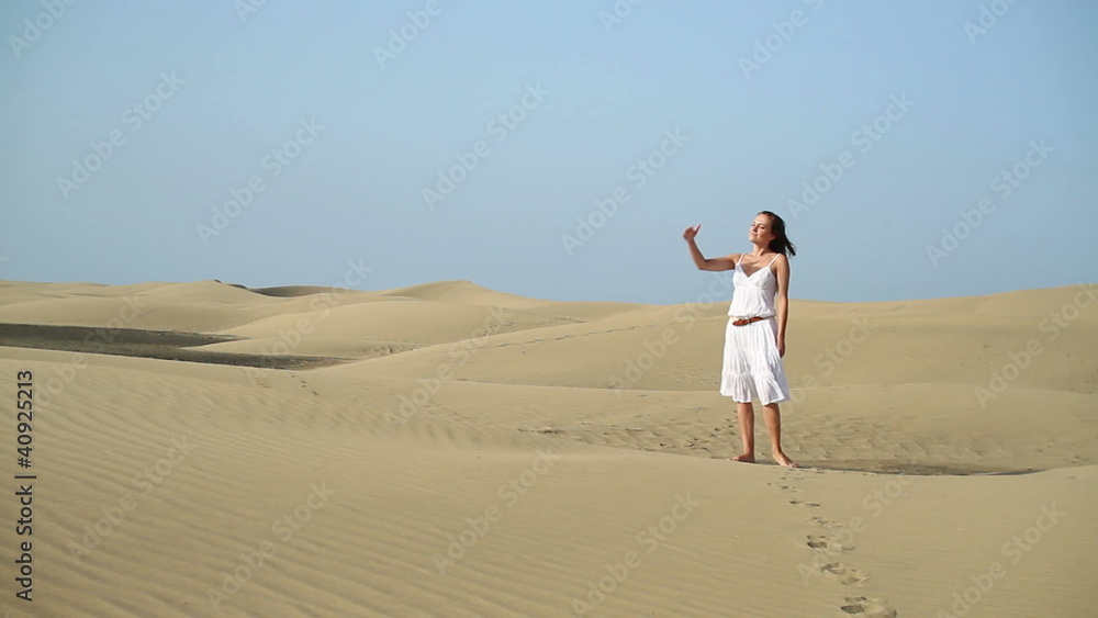 Young woman in white dress looking around at the desert Young woman in white dress looking around at the desert