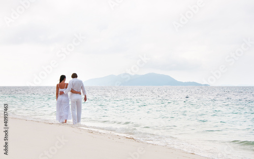 Picture of romantic young couple having a walking on the sea sho
