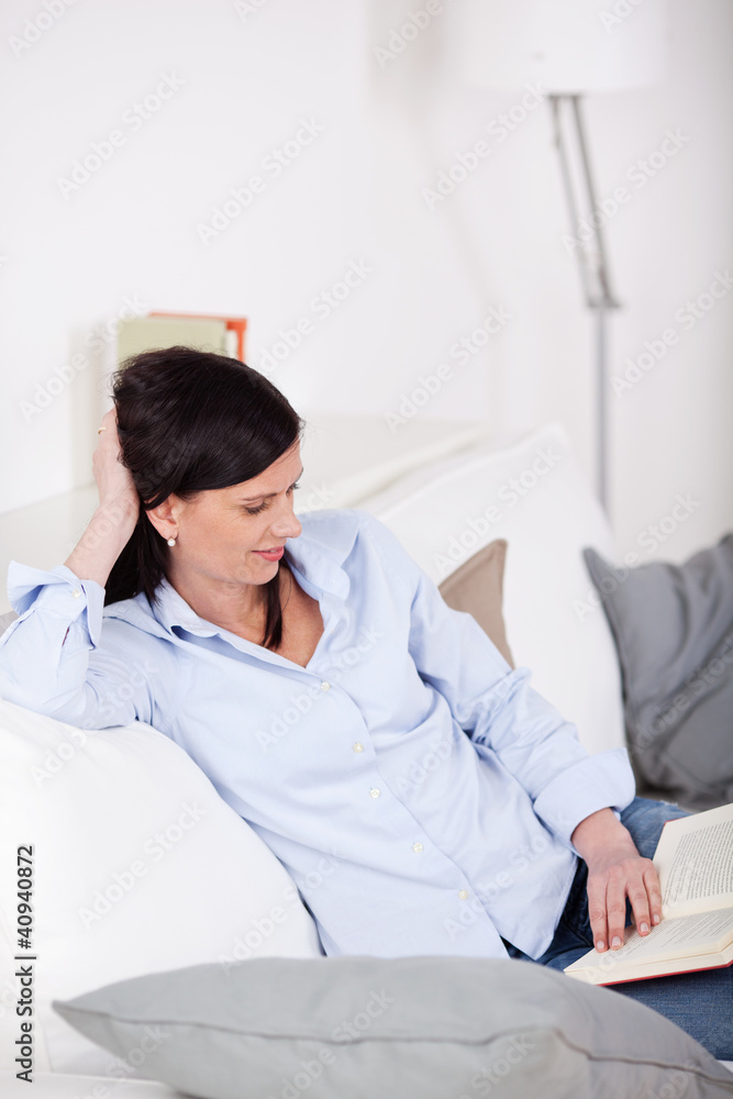 frau mit einem buch auf dem sofa frau mit einem buch auf dem sofa