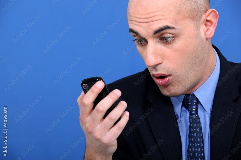 Shocked businessman with mobile telephone