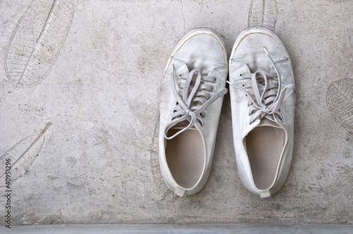 old white sneaker on cement floor