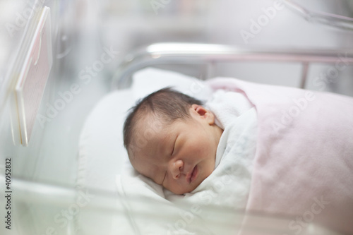 new born infant asleep in the blanket in delivery room photo