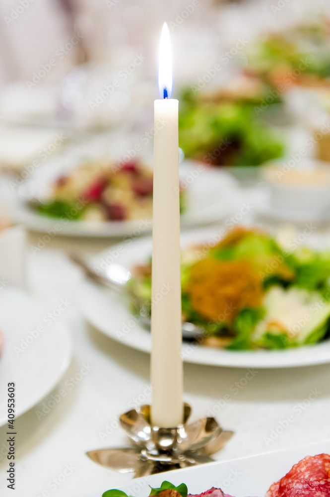 Burning candle at dinner table Burning candle at dinner table