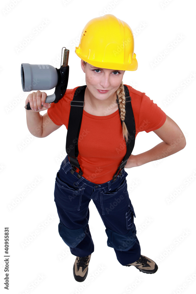 Female laborer holding blowtorch Female laborer holding blowtorch