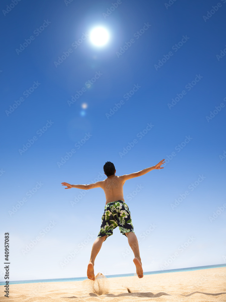 happy young man jumping on the beach happy young man jumping on the beach