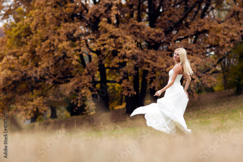 Happy dancing bride on autumn forest