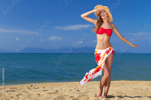 Girl wearing bikini and hat, posing at the beach