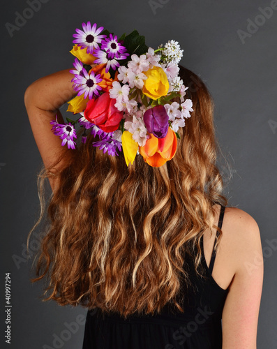 Wonderful, blond, curly hair and bouquet of spring flowers