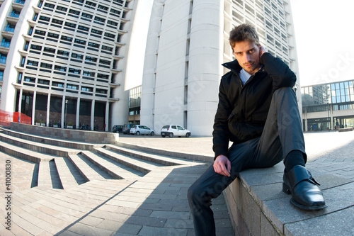 Young elegant man portrait with building background. photo