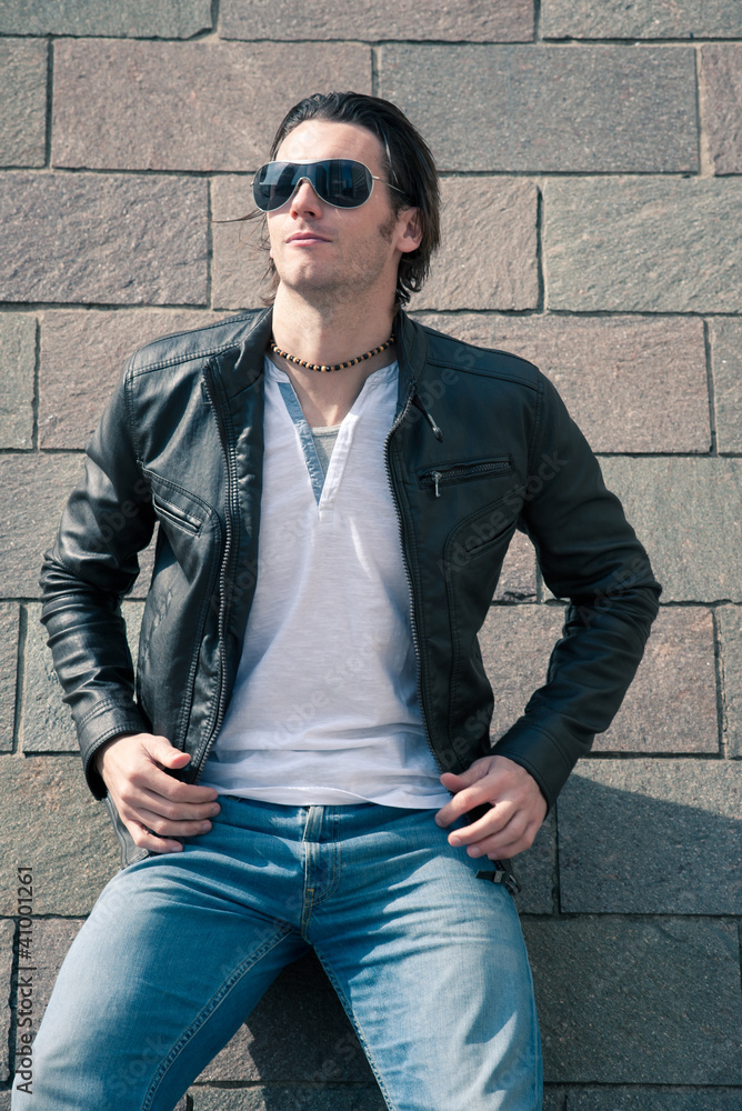 Close up of Young casual man portrait against wall. Close up of Young casual man portrait against wall.