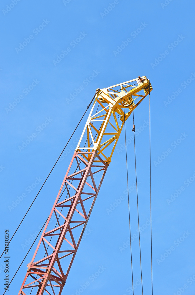 Mobile yellow construction tower crane against blue sky