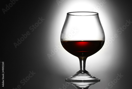 Glass of cognac on grey background