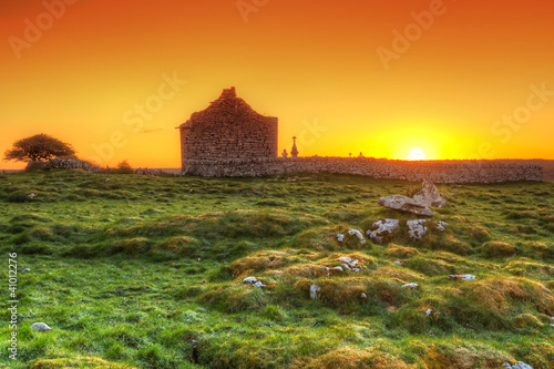 Ruins of old Irish chapel in Burren at sunrise photo