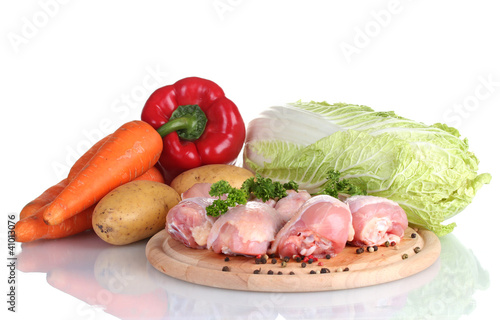 Fresh vegetables with raw chicken drumsticks and pork steak