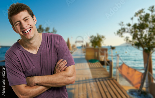 Young smiling relaxed man at the beach in a summer day