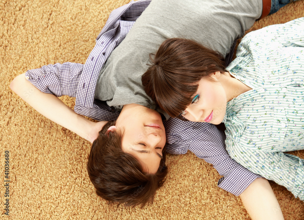 Closeup of happy young couple lying on floor. Top view Closeup of happy young couple lying on floor. Top view