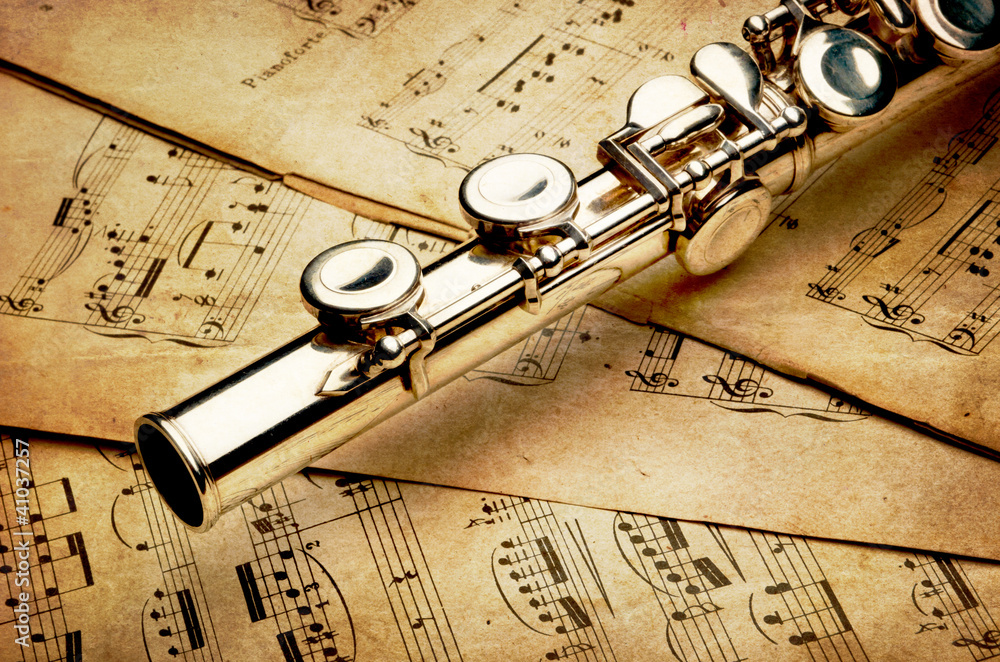 Fototapeta premium Silver flute on an ancient musical background