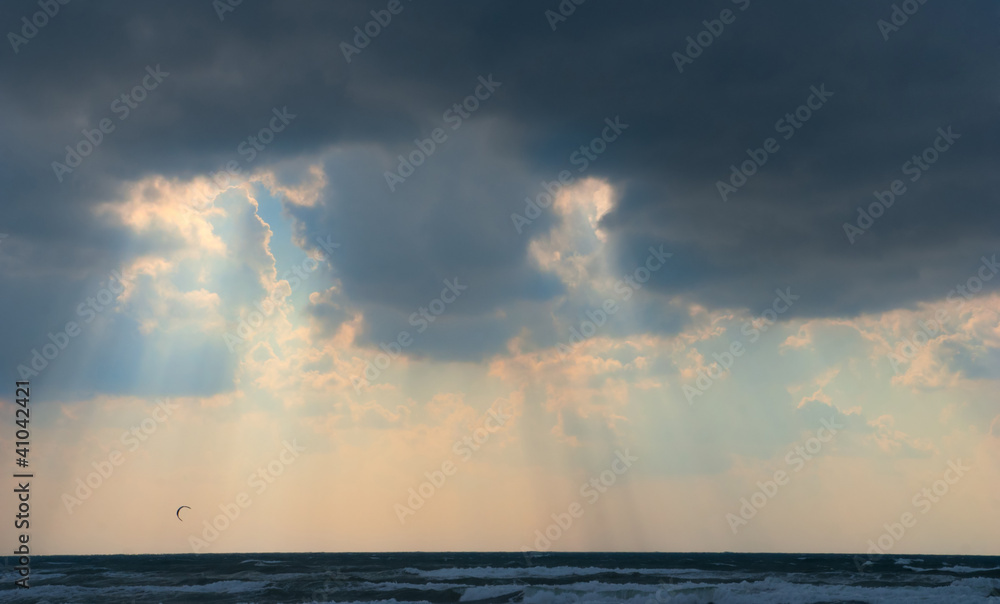 Sun behind dark storm clouds over the sea Sun behind dark storm clouds over the sea