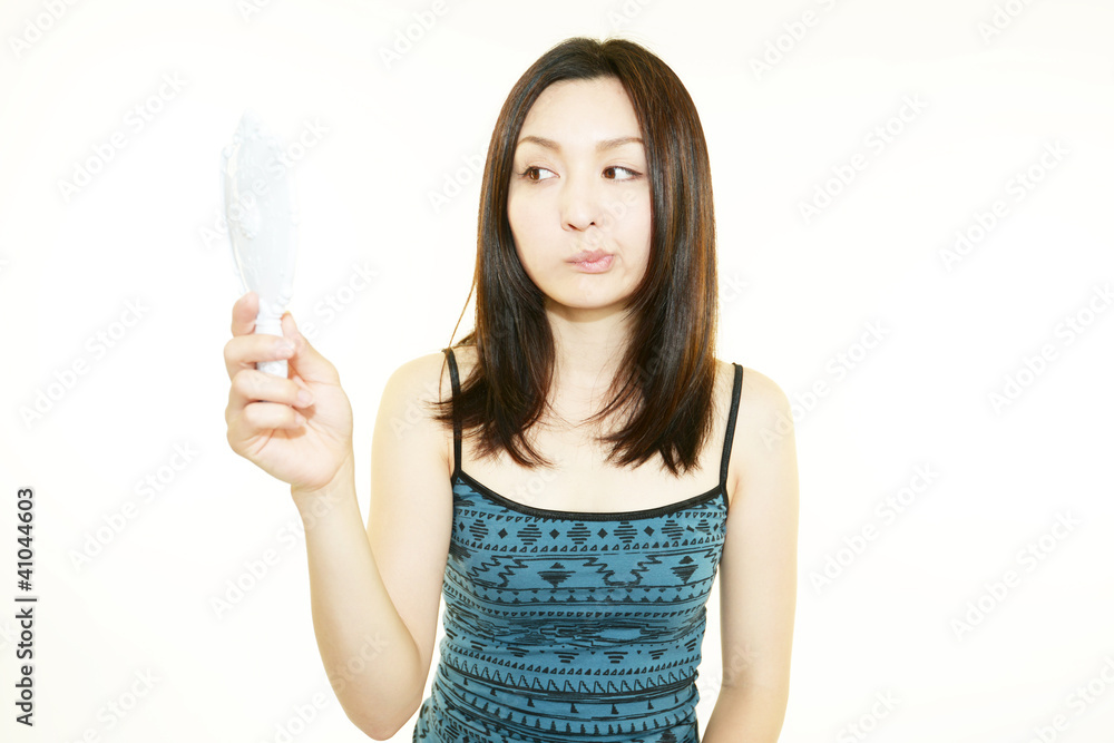 シミを気にする手鏡を持った女性 シミを気にする手鏡を持った女性