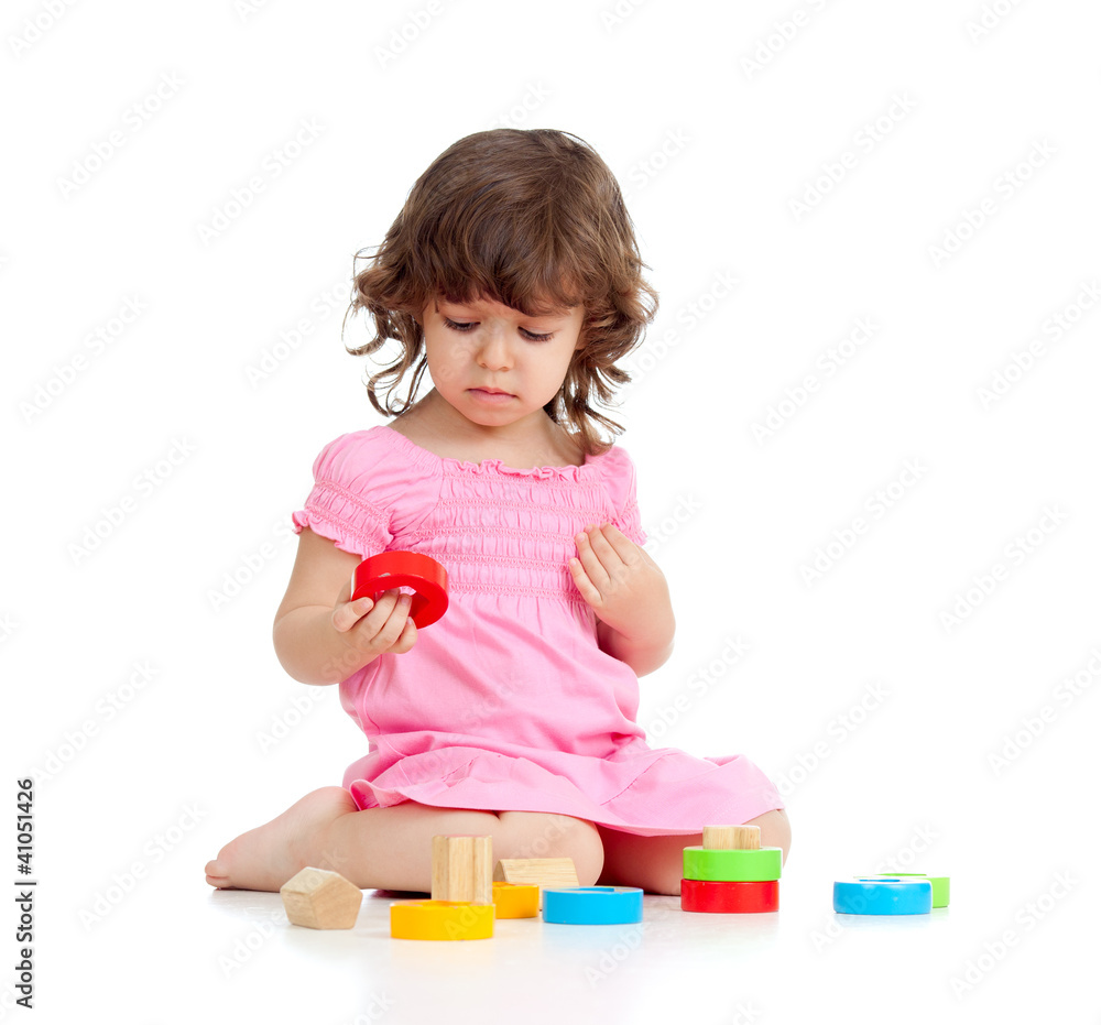 Funny little child playing with colorful toys, isolated over whi Funny little child playing with colorful toys, isolated over whi