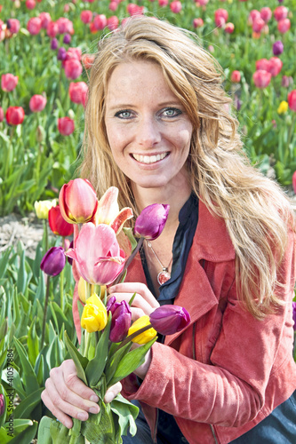 Beautiful young woman with tulips in the tulipfields photo