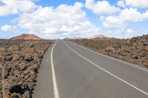 Road through lava rocks and volcanic mountains. Los Hervideros.