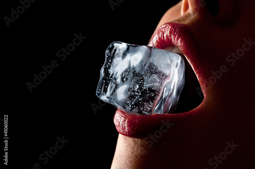 Ice cube in woman's mouth. photo
