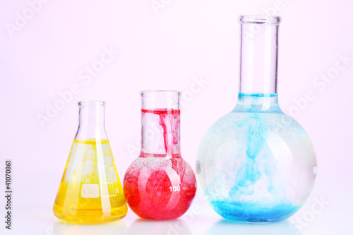 brightly ink in a flask with water on pink background