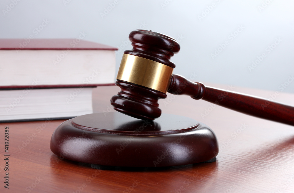 gavel and books on wooden table on gray background gavel and books on wooden table on gray background