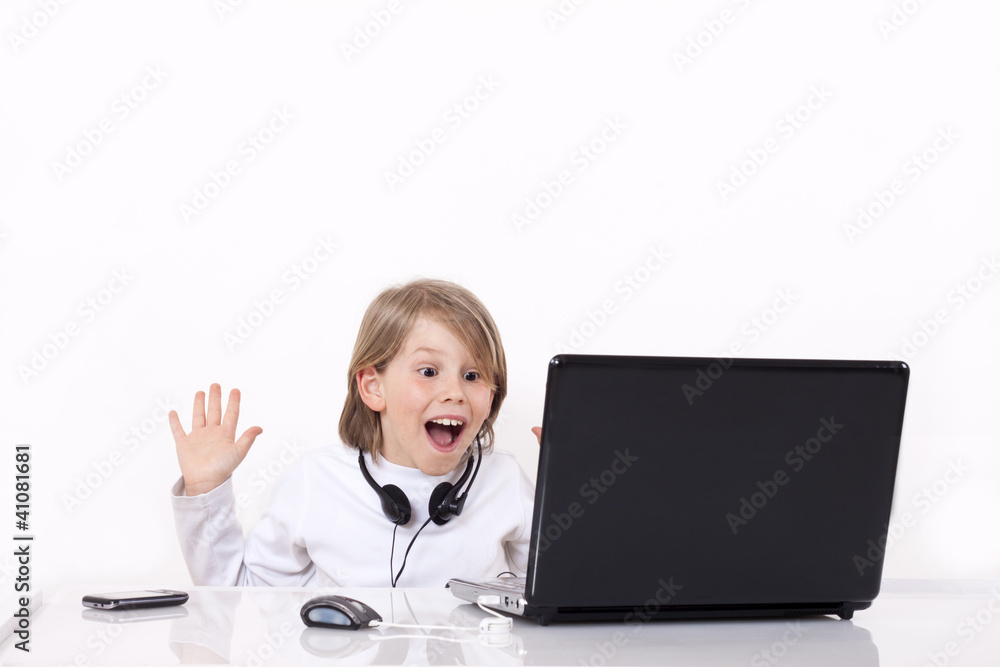 Happy kid surprised behind the laptop computer Happy kid surprised behind the laptop computer