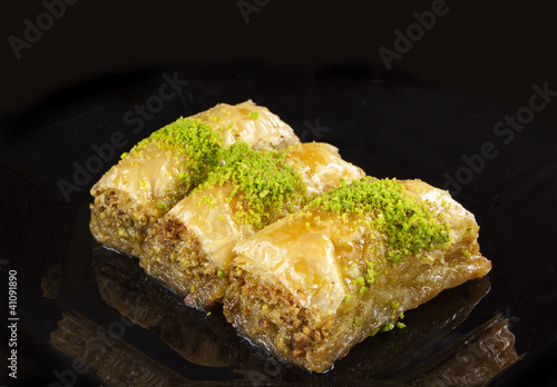 golden baklava dessert isolated on black background