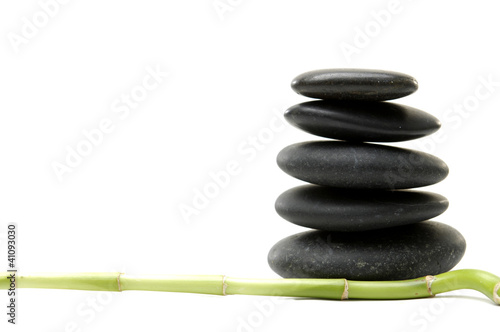 Isolated lucky bamboo stick and stacked black stones