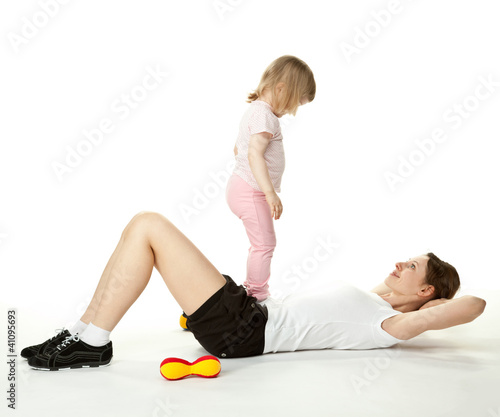 Young mother doing sport exercises with her little daughter