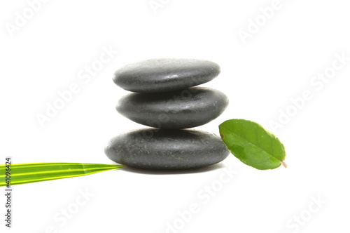 Zen pebbles balance with green leaf