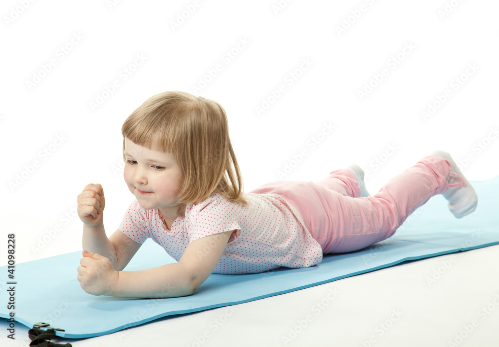 Active baby girl exercising lying on a training mat Active baby girl exercising lying on a training mat