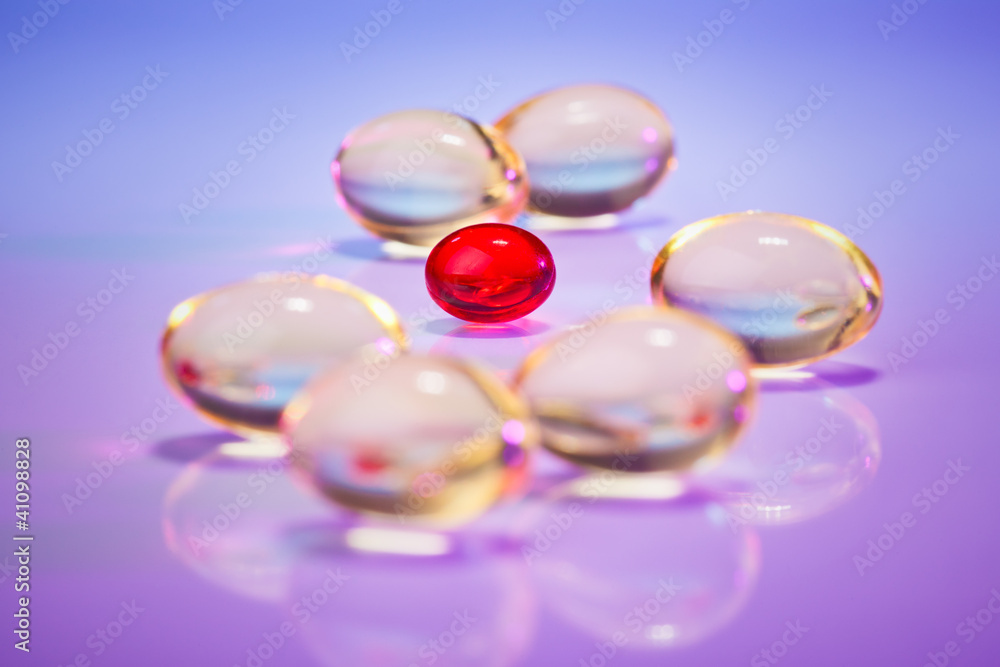 Pills (capsules) of cod-liver oil on violet, macro view with sel Pills (capsules) of cod-liver oil on violet, macro view with sel