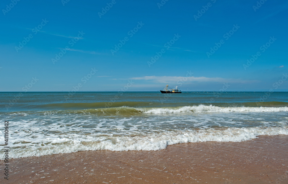 Trawler fishing at sea under a blue sky