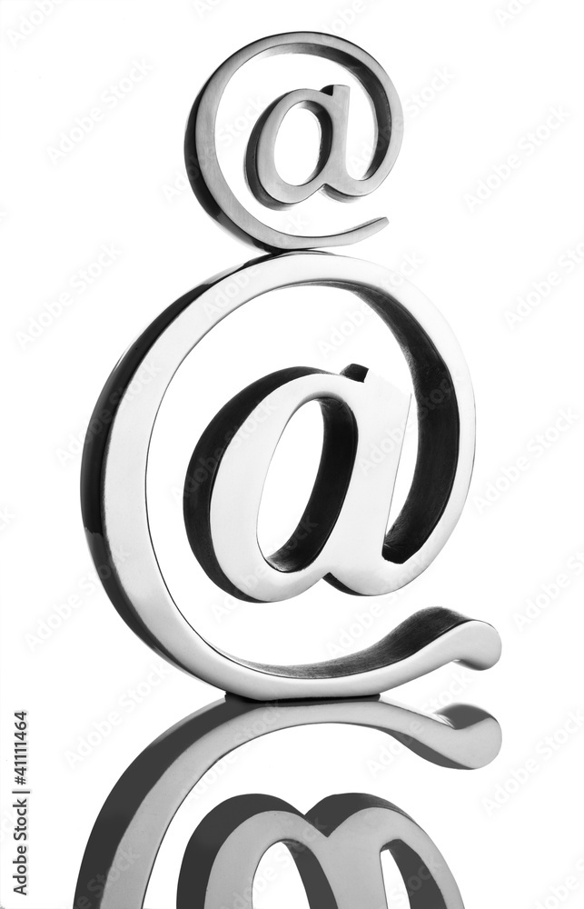 At symbol paperweight on a reflective surface At symbol paperweight on a reflective surface