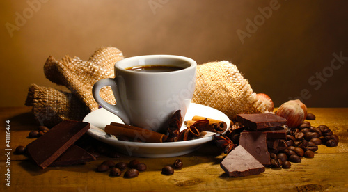 coffee cup and beans, cinnamon sticks, nuts and chocolate