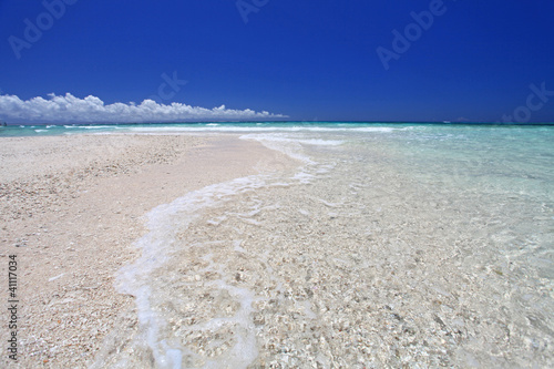 南国沖縄の綺麗なビーチに打ち寄せる透明な波