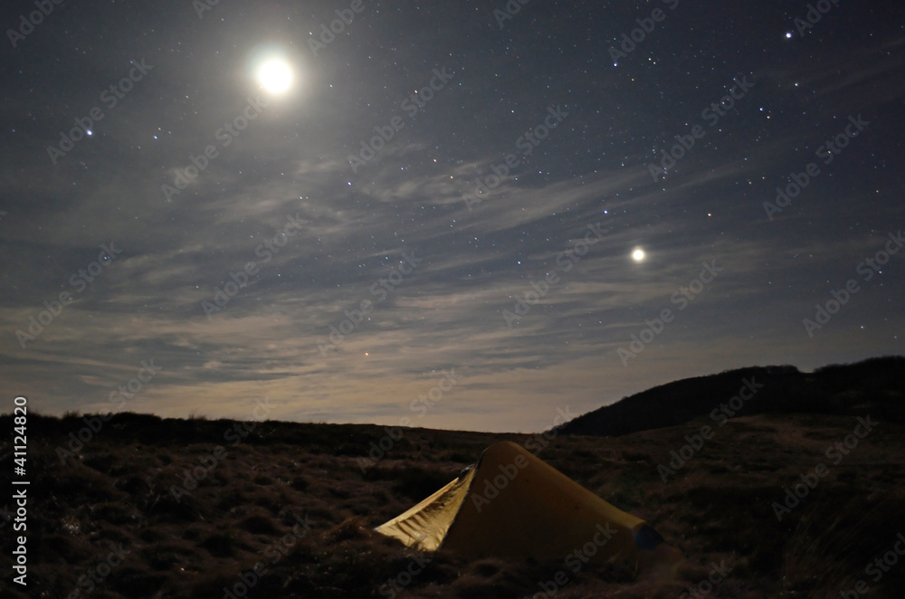 yellow tent under starry sky and moonlight