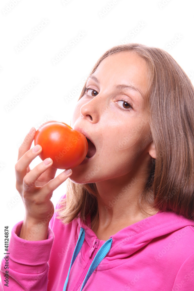 Young woman eating a tomato, isolated Young woman eating a tomato, isolated