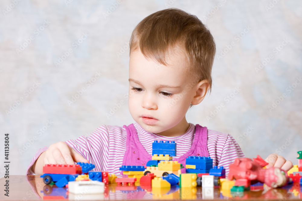 The child in a pink dress with toys The child in a pink dress with toys