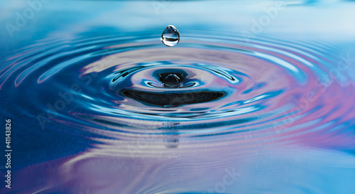 Drop of pure fresh water falls in water