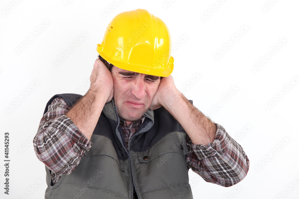 Construction worker holding his hands over his ears Construction worker holding his hands over his ears