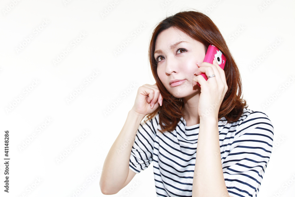 携帯電話で会話中の笑顔の女性 携帯電話で会話中の笑顔の女性